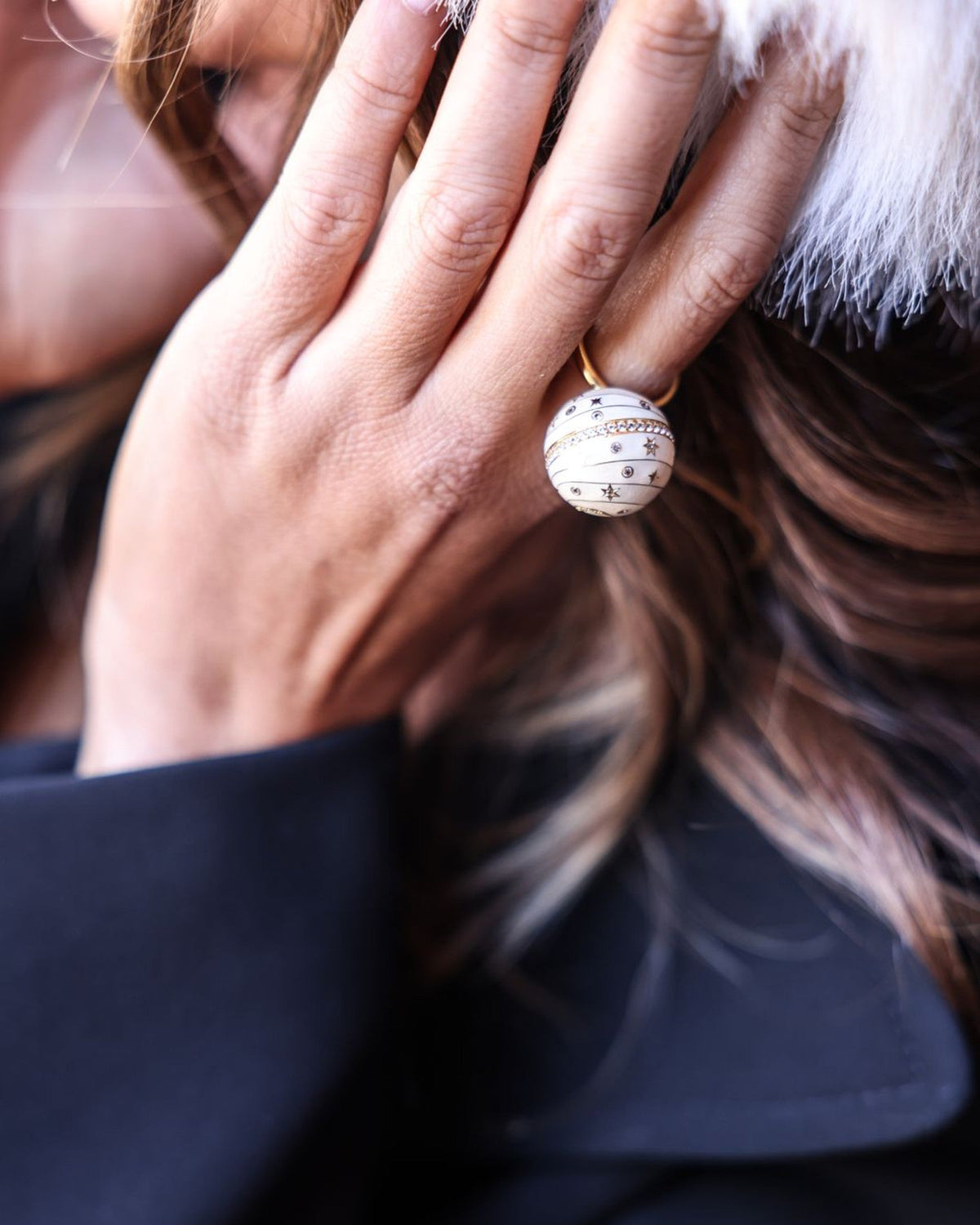 Bubble Circle I worn on the hand — 18k gold sphere ring with ivory grand feu enamel, engraved stars and a pavé diamond band, by Sandrine Barabinot